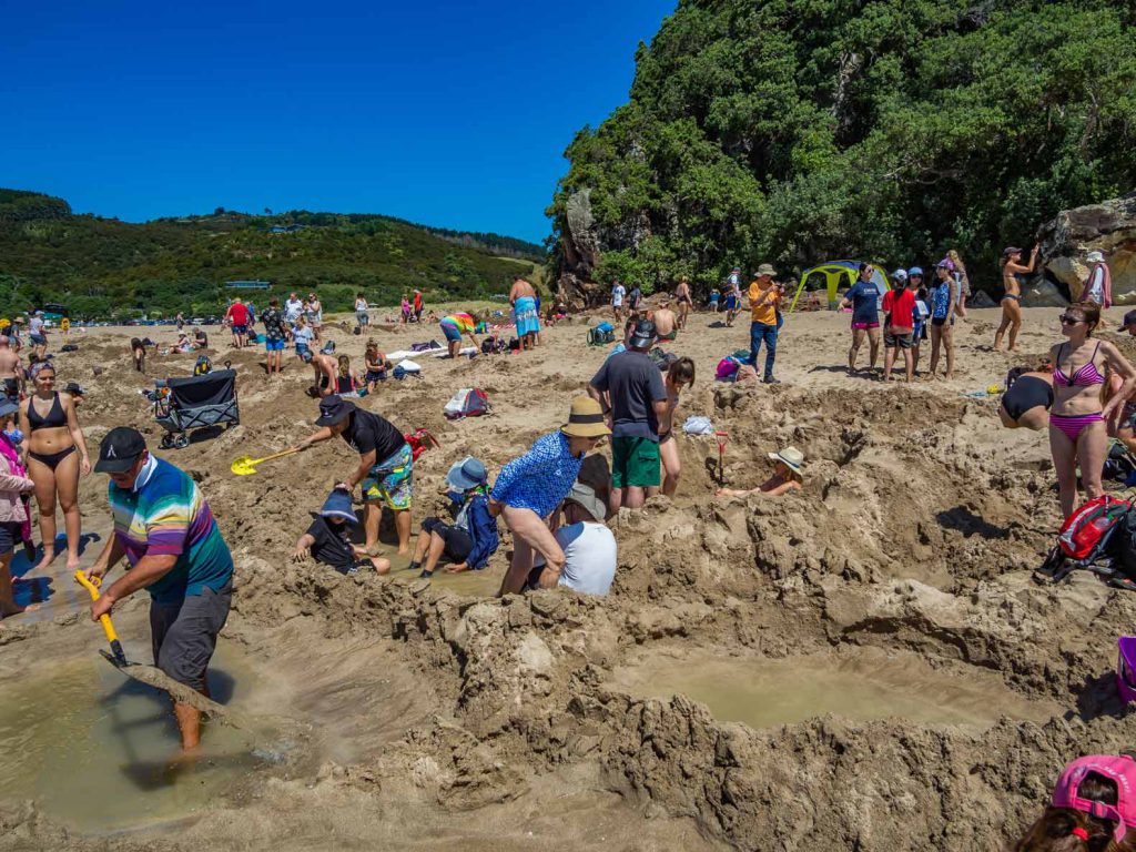 People digging holes at Hot Water Beach, Coromandel, North Island, New Zealand