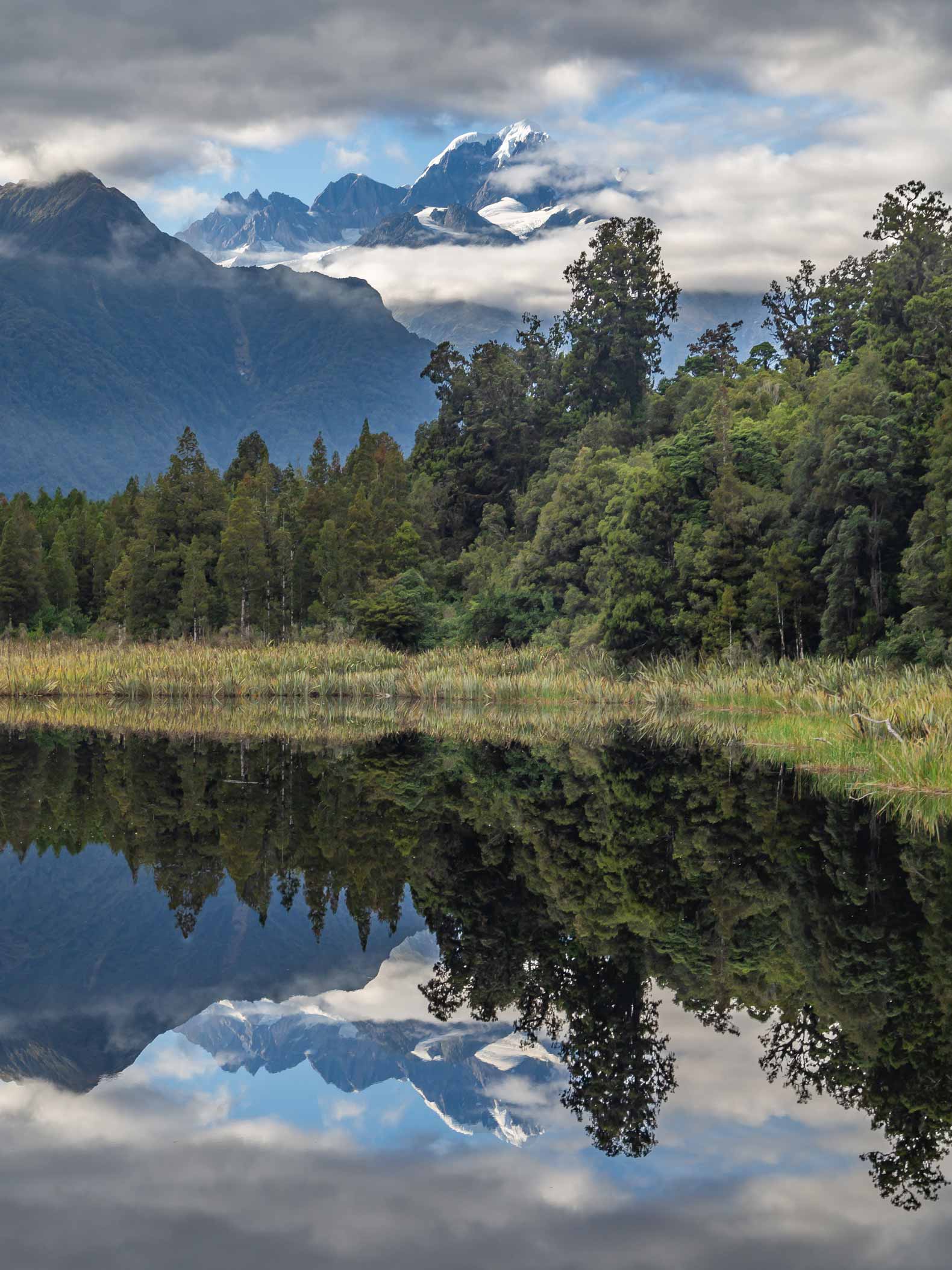 The image of Fox glacier reflected in Lake Mattheson, New Zealand.