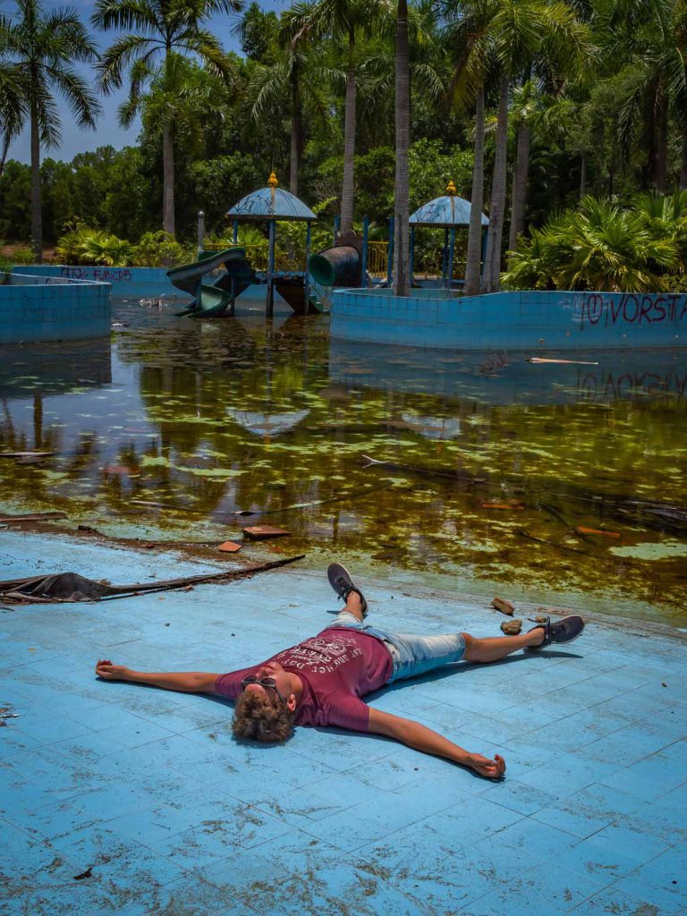 Geert pretending to chill by the pool of the abandoned water park of Hue